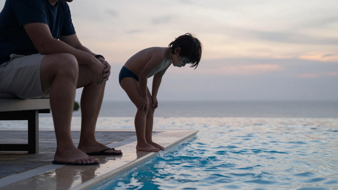 Ребёнок касается воды в бассейне, родитель сидит вдали, наблюдая.