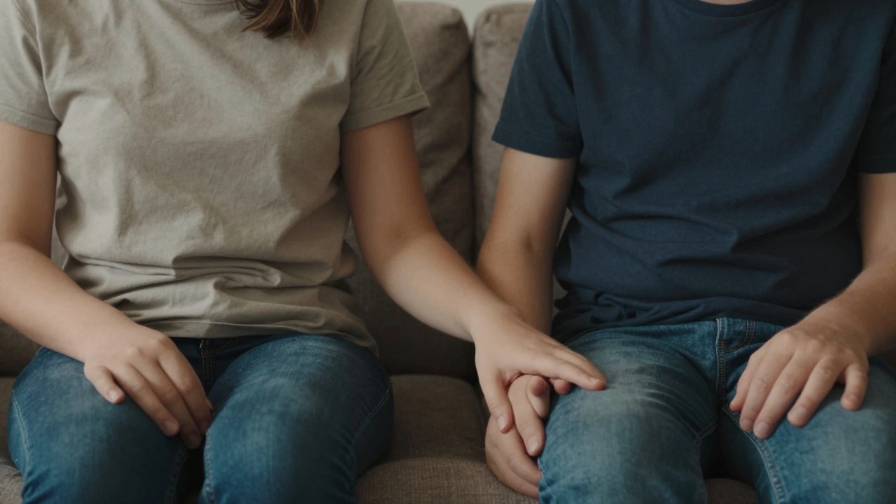 Родитель и ребёнок сидят рядом на диване в тишине, их руки почти касаются, тёплый свет лампы.